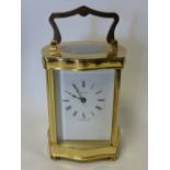 A brass cased Henley carriage clock with white enamel dial,