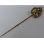 Early 20th century 9ct gold (tested) pin, the finial set with Peridot stones and seed pearls, 6.