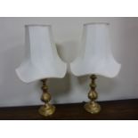 Pair of decorative brass table lamps with cream shades, approx 53cms in height.