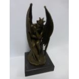 Cast Bronze after Milo of a horned & winged devil figure clasping a cross and seated on a rock,