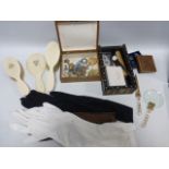 An eclectic mix of items including a three piece ivory back mirror and brush set,