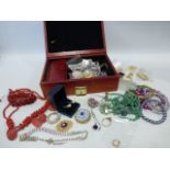 Jewellery box containing assorted jewellery include a pair of gold hoop earrings.