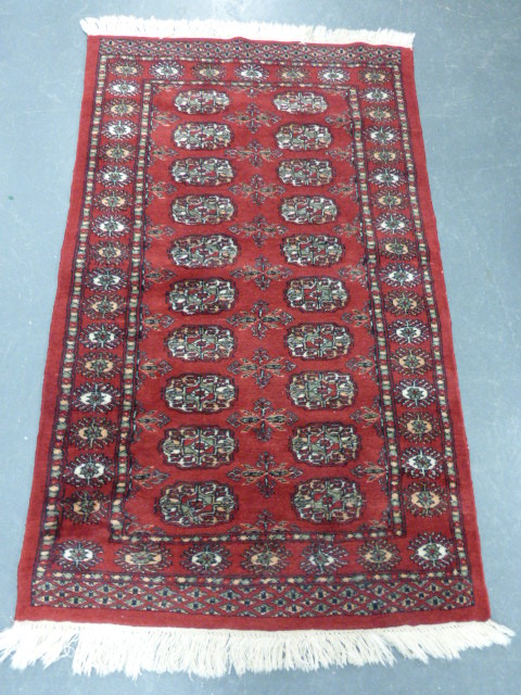 Iranian rug with two rows of ten guls, 133x82cms.