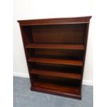 Mahogany veneered bookcase with dentil moulding and three adjustable shelves, on plinth support,