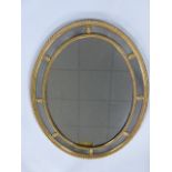 A late 19th/early 20th century Regency style giltwood and gesso oval wall mirror,