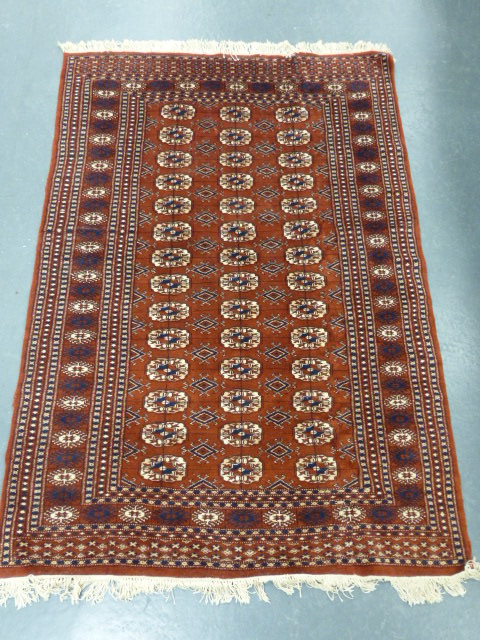 Iranian rug with three rows of fourteen guls, 182x125cms.