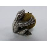 Silver novelty pin cushion in the form of a Frog clutching a ball, stamped 925, 38.5g, 2.