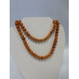 An amber bead necklace with 84 individually knotted beads, 79cms in length, 34.8g.