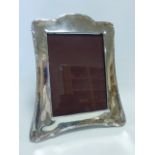Large Edwardian silver photograph frame with tied ribbon border,