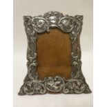 Embossed silver photograph frame hallmarked Birmingham 1904 by makers W H Manton Ltd, 20.5x22.5cms.