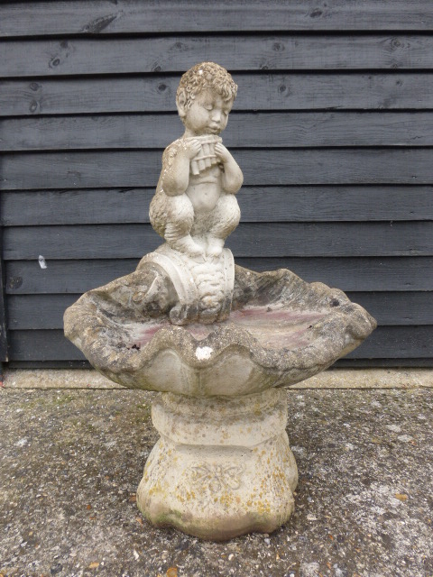 A garden bird bath with a Faun playing pan pipes atop, 75cms in height.