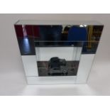 Wall mounted mirrored display block, 51x51cms, together with a model 2CV car.