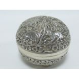 Indian white metal box of flattened spherical form embossed with palm trees and wild animals and