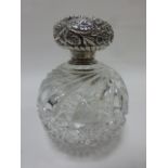 Cut glass globular scent bottle with embossed floral Sterling silver lid, 14cms in height.