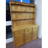 Pine dresser with twin plate rack shelves above three drawers and a three door cupboard base,