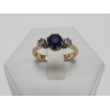 An 18ct gold Sapphire and Diamond three stone ring, size P//Q.