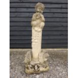 A garden statue of a Faun playing pan pipes atop a column with a squirrel, frog and rabbit at base,