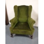 Victorian wingback fireside chair, on cabriole claw and ball front supports and castors.