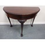 A 20thC mahogany demi lune card table with gadrooned border and internal green felt playing surface,