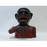 First half 20thC cast iron money bank in the form of a man wearing red jacket & bow tie.