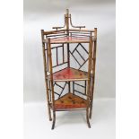 A LATE 19TH CENTURY BAMBOO AND LACQUER CORNER STAND in the Aesthetic taste, fitted three shelves,