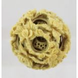 A LATE 19TH CENTURY CARVED IVORY PUZZLE BALL, having outer floral decoration, 4.5cm diameter