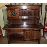 A 'LIBERTY' OAK SIDEBOARD OF ARTS AND CRAFTS DESIGN, the top fitted with an offset glass door