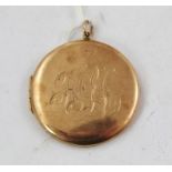 A 9CT. GOLD CIRCULAR LOCKET, having ornamental initialled front "HGL" and plain back