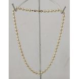 A UNIFORM CULTURED PEARL NECKLACE with 9ct gold clasp, 36cm long
