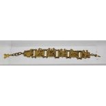 A 1930's EGYPTIAN REVIVAL BRACELET in cast gilt metal with gilt chain clasp