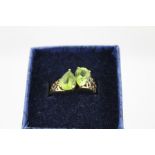 A 9CT GOLD DRESS RING the top claw set with two heart shape green stones, fretted shoulders and