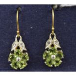 A PAIR OF GOLD COLOURED METAL PERIDOT SET DROP EARRINGS each with a floret of five heart shape