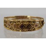 A VICTORIAN GOLD BANGLE the top tooled and set with two diamonds and three rubies with bamboo