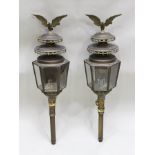 A PAIR OF DECORATIVE BRASS CARRIAGE LANTERNS having cast swag and eagle mounts, candle fittings,