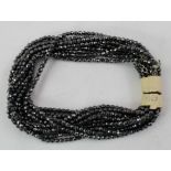 A 1940's FACETTED HEMATITE NECKLACE of twelve rows, each with a bolt ring clasp, 20cm long