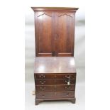 A GEORGE III OAK BUREAU BOOKCASE, the top fitted two arched panel doors, over a base with writing