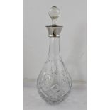 A CUT GLASS DECANTER of tear-drop form with silver collar and facet cut stopper