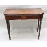 A 19TH CENTURY MAHOGANY FOLDOVER TEA TABLE having reeded edge, on four ring turned legs