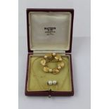 A LATE 20TH CENTURY GOLD COLOURED METAL BROOCH set with six cultured pearls and textured sections