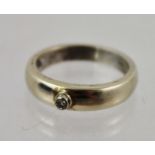 A DIAMOND SOLITAIRE on a barrel banded gold coloured metal shank, stamped 18k., size M
