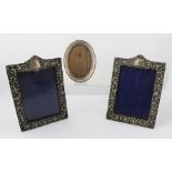 X** H** A PAIR OF PRESSED SILVER VICTORIAN STYLE RECTANGULAR PHOTOGRAPH FRAMES, each having scroll