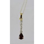 A RUBY AND DIAMOND PENDANT, fashioned as a bar with single pear cut stone and small diamond bar,