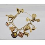 A COMBINED 9CT GOLD AND YELLOW METAL CHARM BRACELET, the charms include a rabbit, top hat, sailing