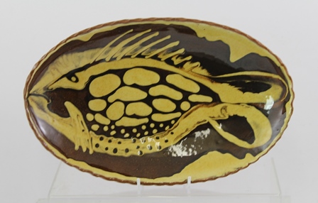 JOHN SOLLY (1928-2004) A SLIPWARE DECORATED TERRACOTTA OVAL SERVING BOWL of stylised fish design,