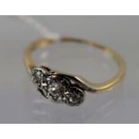 A 9CT GOLD CROSSOVER STYLE RING, set with three diamonds, size M 1/2