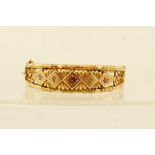 A VICTORIAN 9CT GOLD BANGLE, tooled with stylised bamboo and set with three rubies and two diamonds,