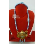 AN ART NOUVEAU TURQUOISE GLASS SINGLE ROW BEAD NECKLET, with cast female mask pendant and Venetian