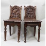 A PAIR OF 19TH CENTURY CARVED OAK HALL CHAIRS, with 16th century style Romayne heads in roundels