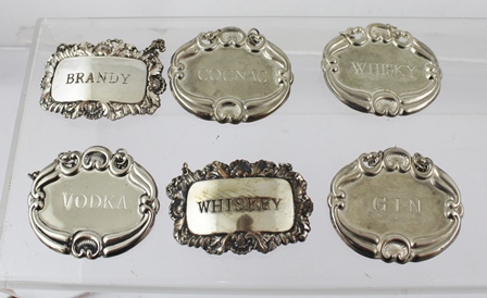 A SELECTION OF SIX ENGRAVED AND PRESSED PLATED DECANTER LABELS, "Whisky", "Whiskey", "Cognac", "