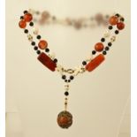 A 20TH CENTURY CORNELIAN AND CARVED WHITE STONE MATERIAL NECKLET of alternate crosses and skulls,